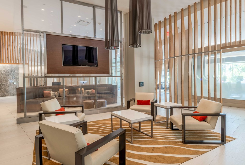 a lobby with chairs and tables and a television